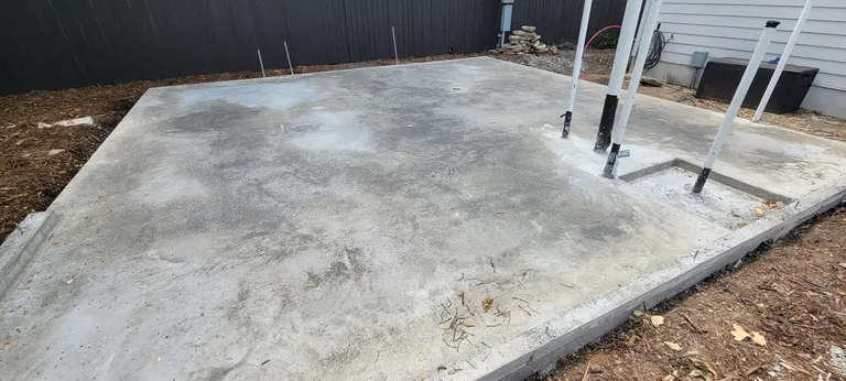 The same slab poured and finished, with the plumbing stub-ups left proud.