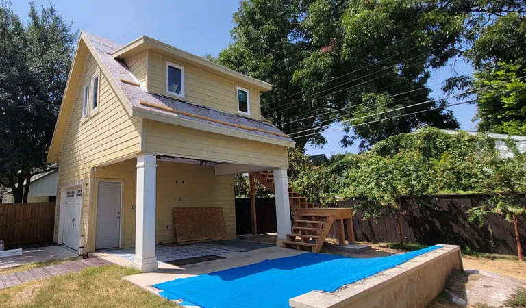 Closed in, sided and primed, with the roof pitch and trim matched to the main house.