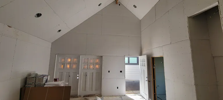 Insulation in and drywall hung, under the vaulted ceiling.