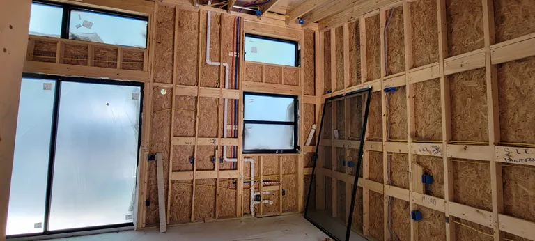 Electrical and plumbing run through open walls and inspected.